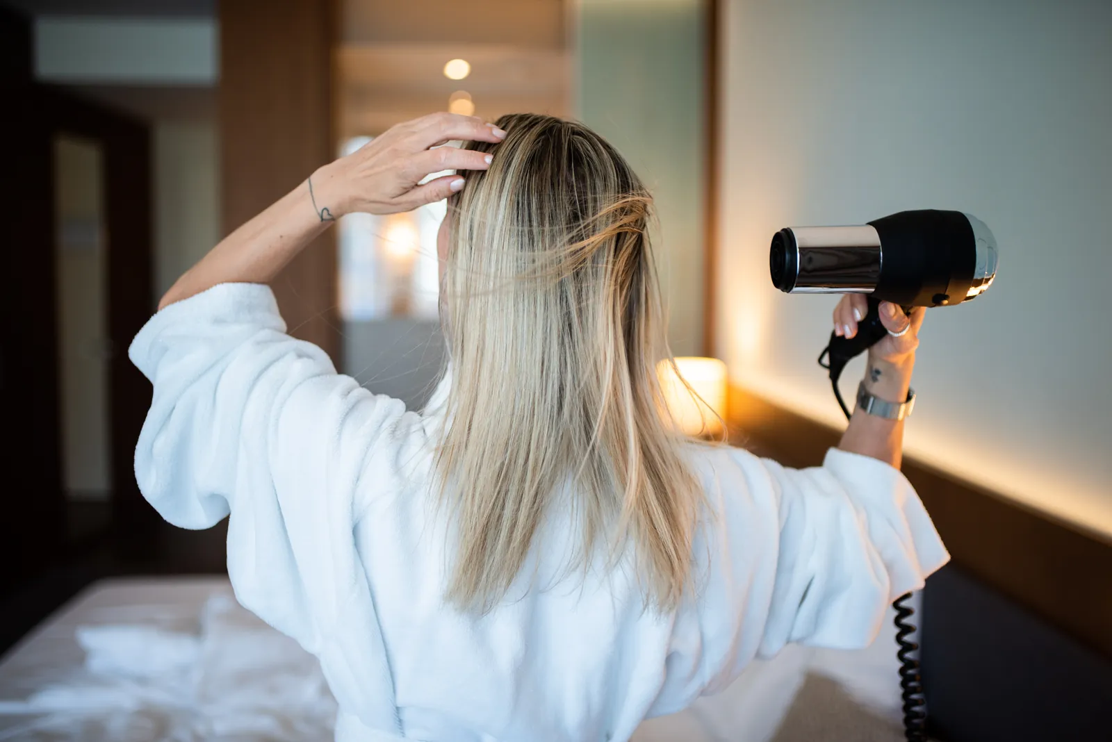 Femme qui se sèche les cheveux, la main sur le cuir chevelu
